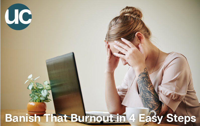 Banish That Burnout In Four Easy Steps Featured Image - A woman sits in front of her laptop with her head in her hands.